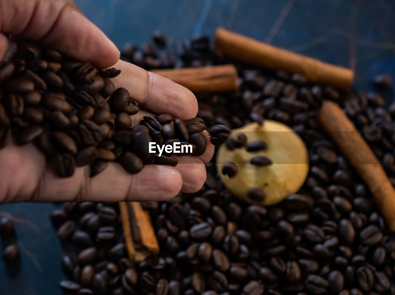 food and drink, roasted coffee bean, food, coffee, hand, freshness, drink, close-up, brown, raw coffee bean, indoors, large group of objects, holding, abundance, roasted, chocolate chip, fruit, produce, healthy eating