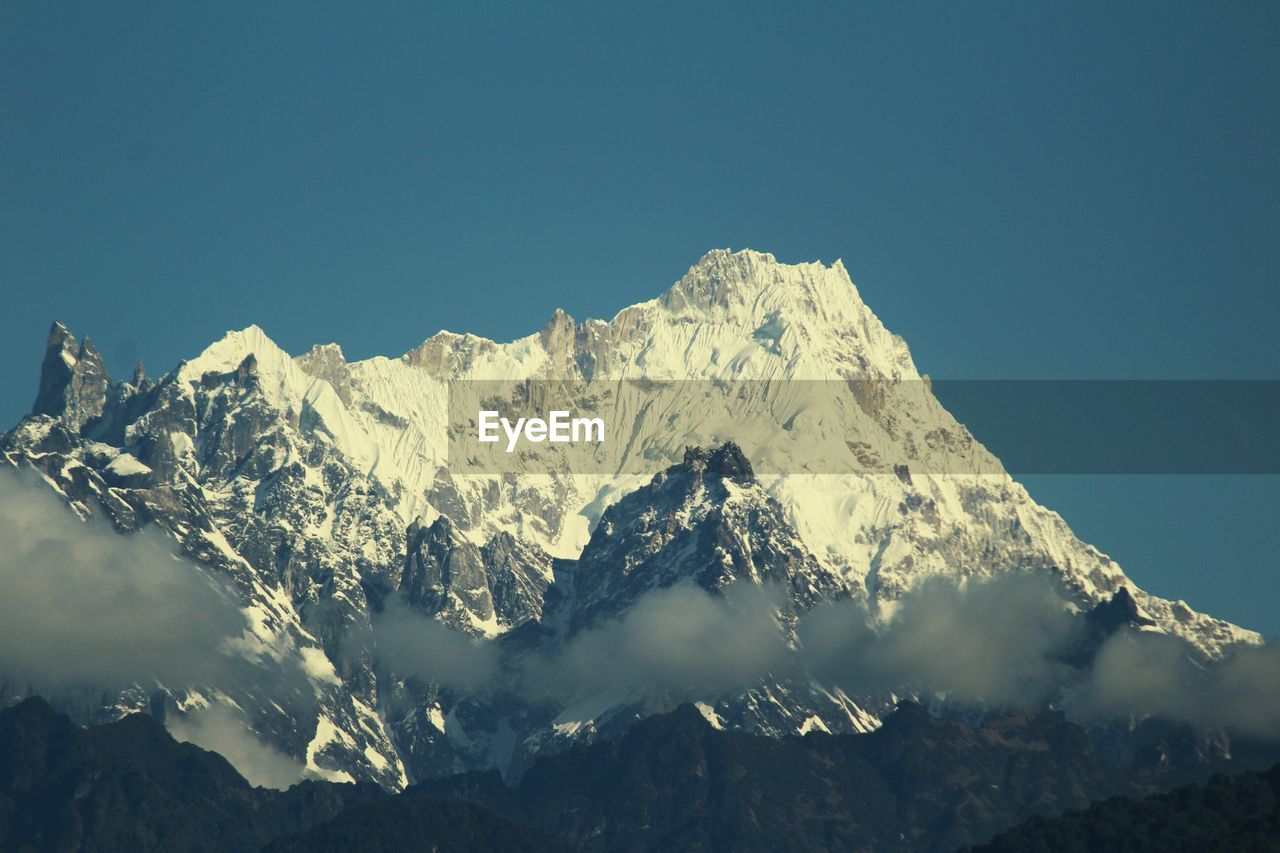 Scenic view of snowcapped mountain against clear blue sky