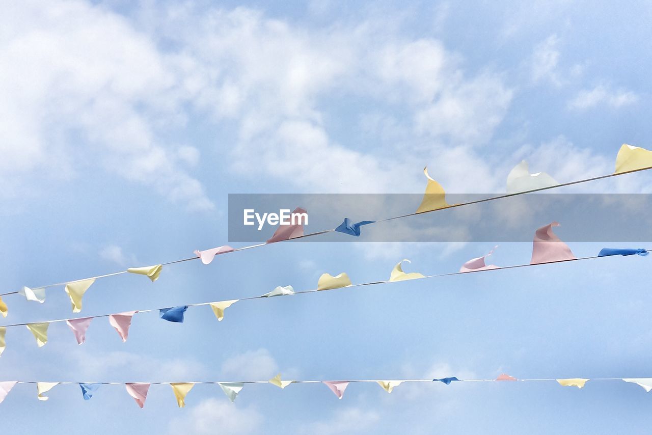 Low angle view of bunting against cloudy sky