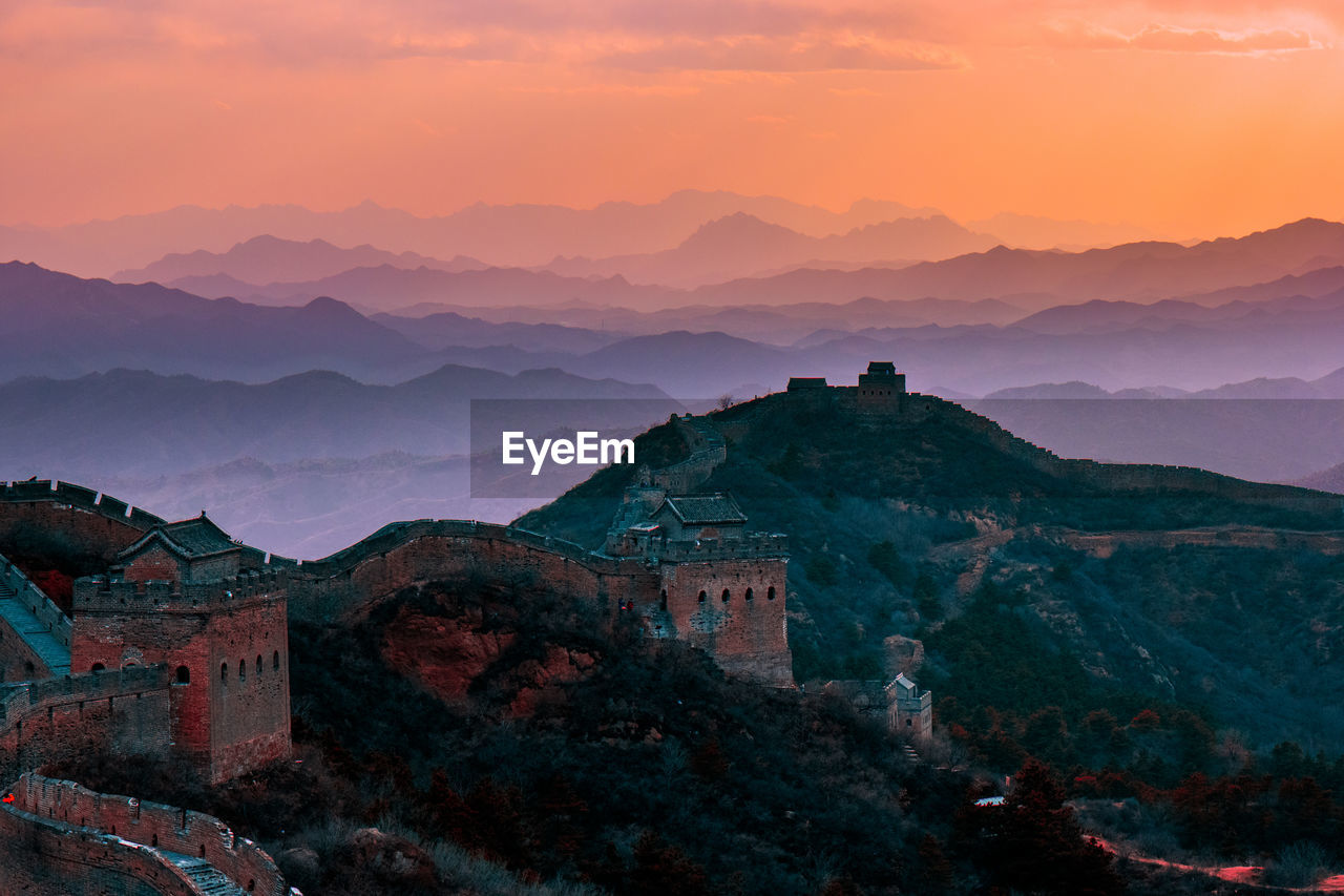 Scenic view of great wall of china on mountain against sky during sunset