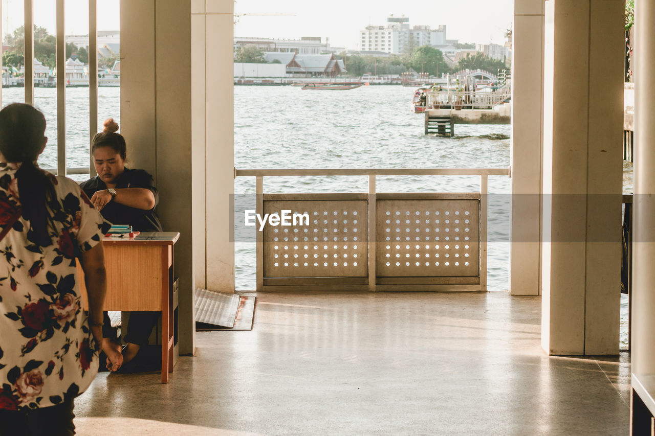 REAR VIEW OF PEOPLE SITTING ON TABLE