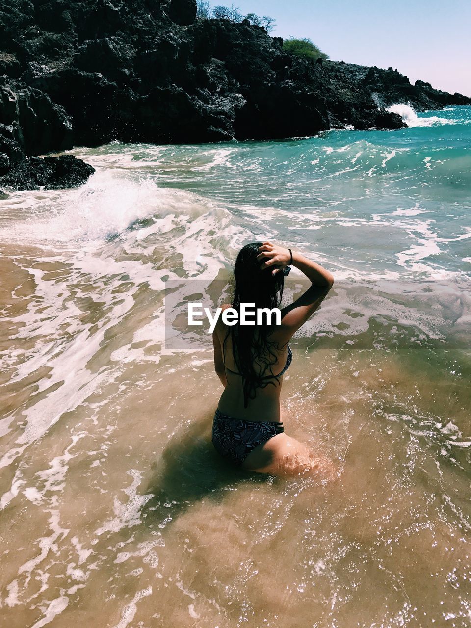 WOMAN STANDING BY SEA AGAINST SKY