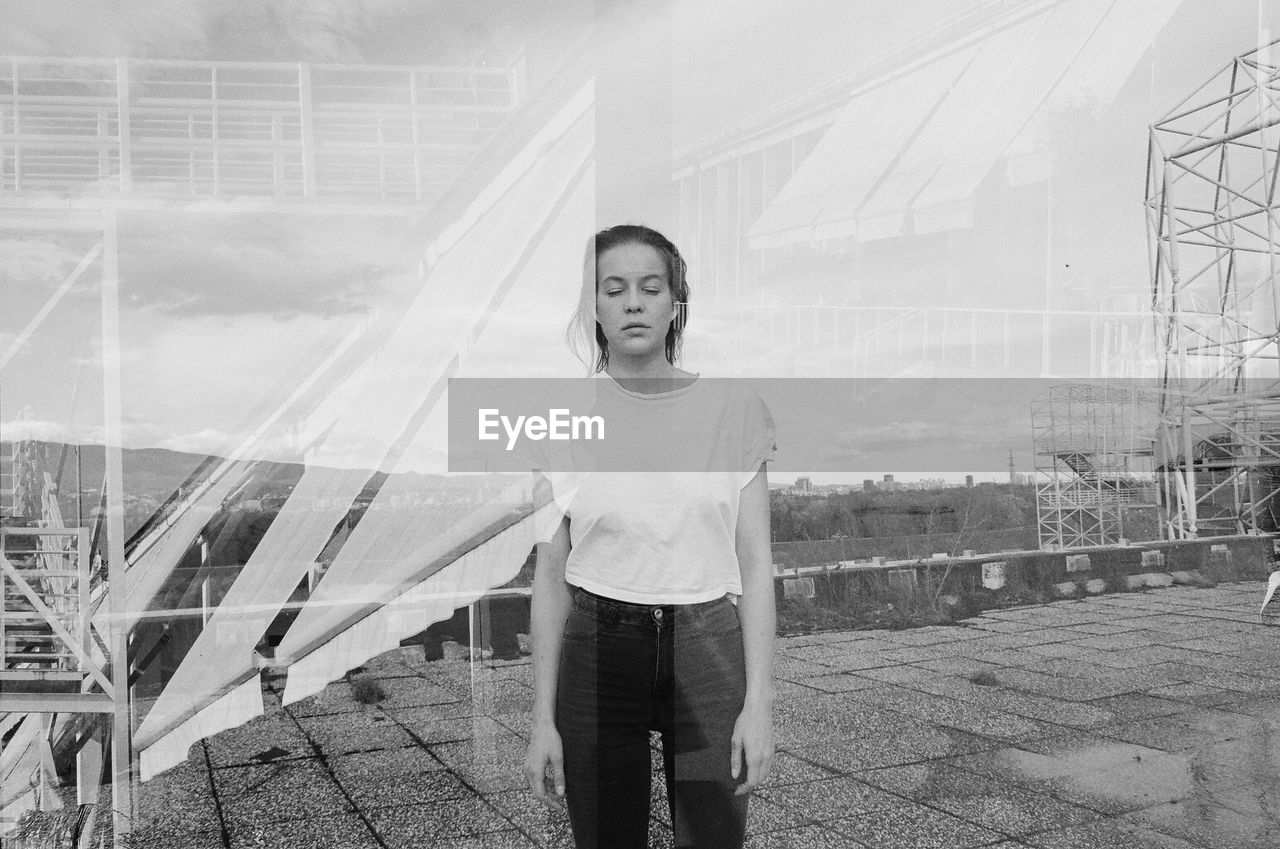 Woman standing outdoors seen through glass