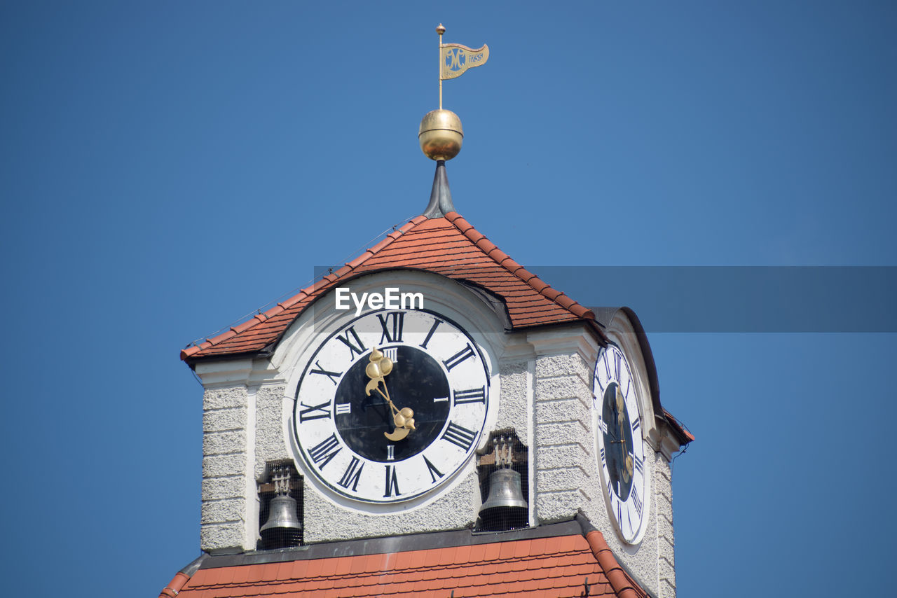 Low angle view of clock tower against clear blue sky