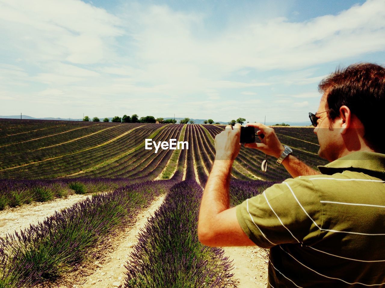 Man photographing agricultural field