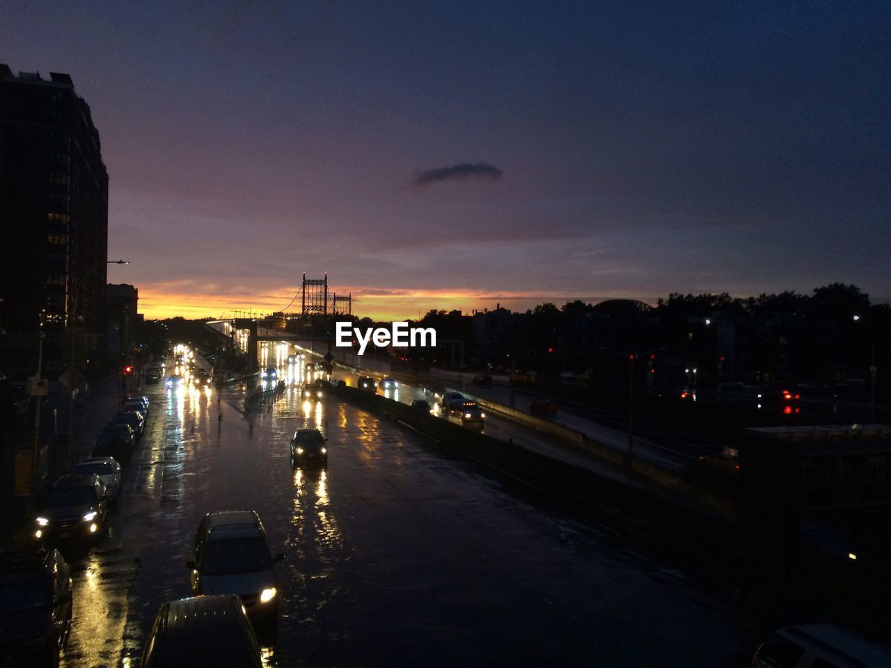 VIEW OF CITY STREET AND BUILDINGS AT SUNSET