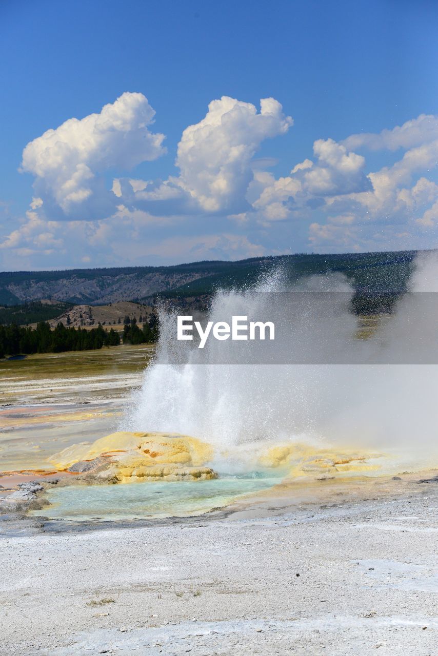 Geyser emitting smoke at yellowstone national park against sky