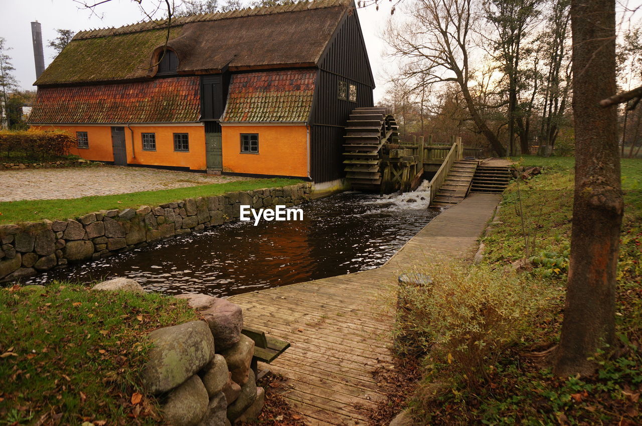 Water wheel by house in village