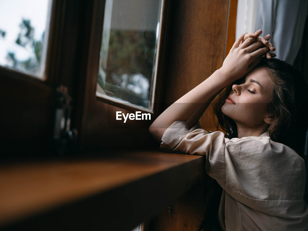 side view of young woman looking through window