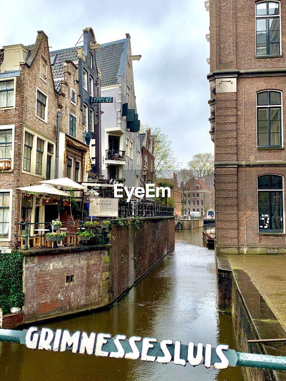 architecture, waterway, canal, building exterior, built structure, water, town, city, building, nature, neighbourhood, cityscape, sky, urban area, day, no people, residential district, cloud, outdoors, travel destinations, transportation, street, window, text, communication, house, travel, tourism, residential area