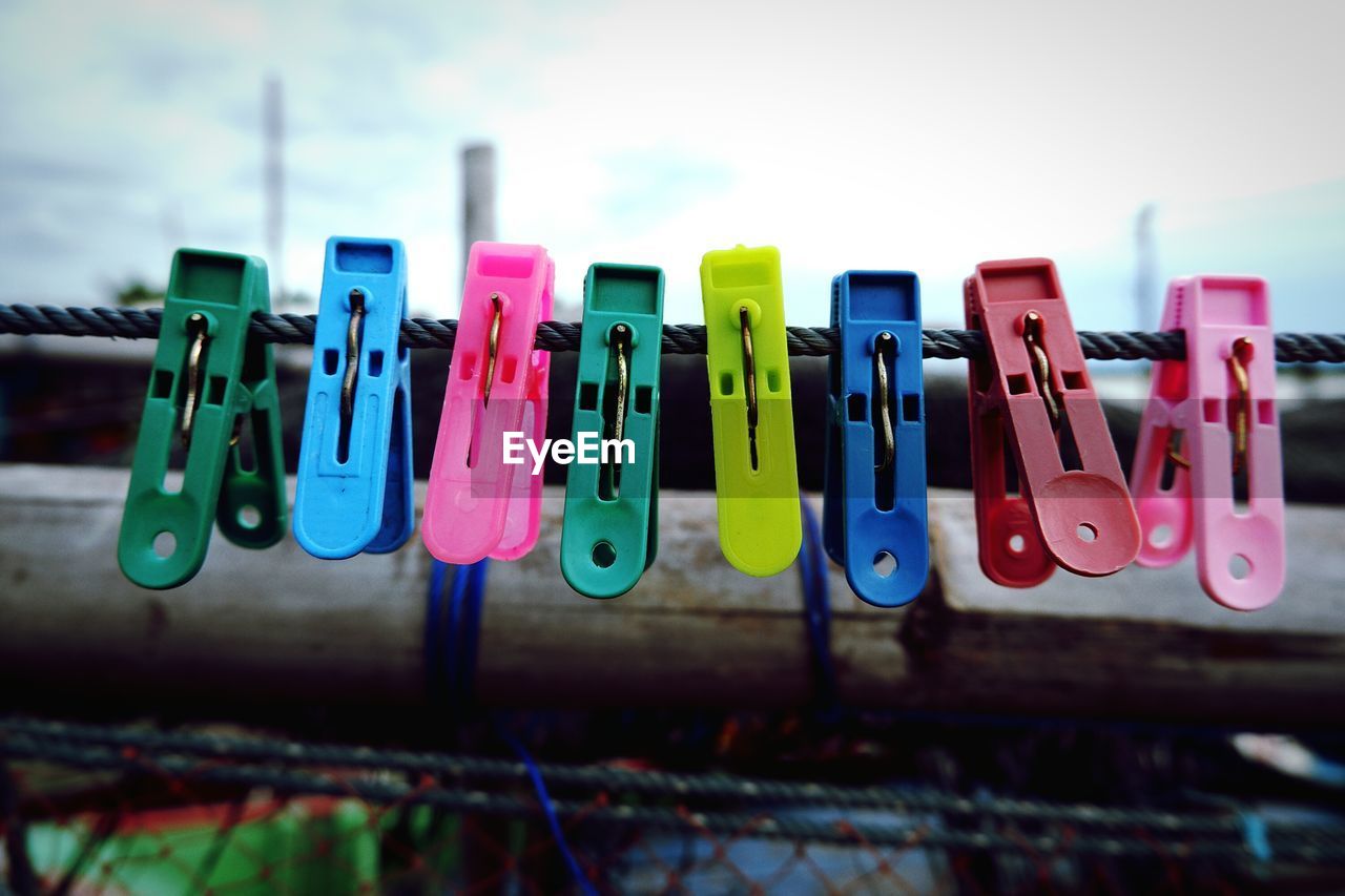 CLOSE-UP OF MULTI COLORED CLOTHESPINS HANGING