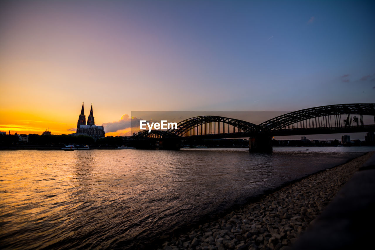 VIEW OF BRIDGE OVER RIVER AT NIGHT