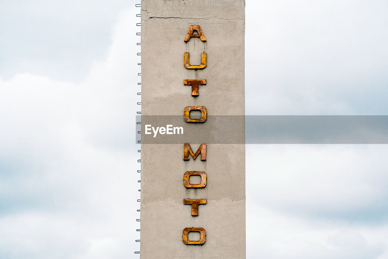 Auto moto rusty letters on concrete tower