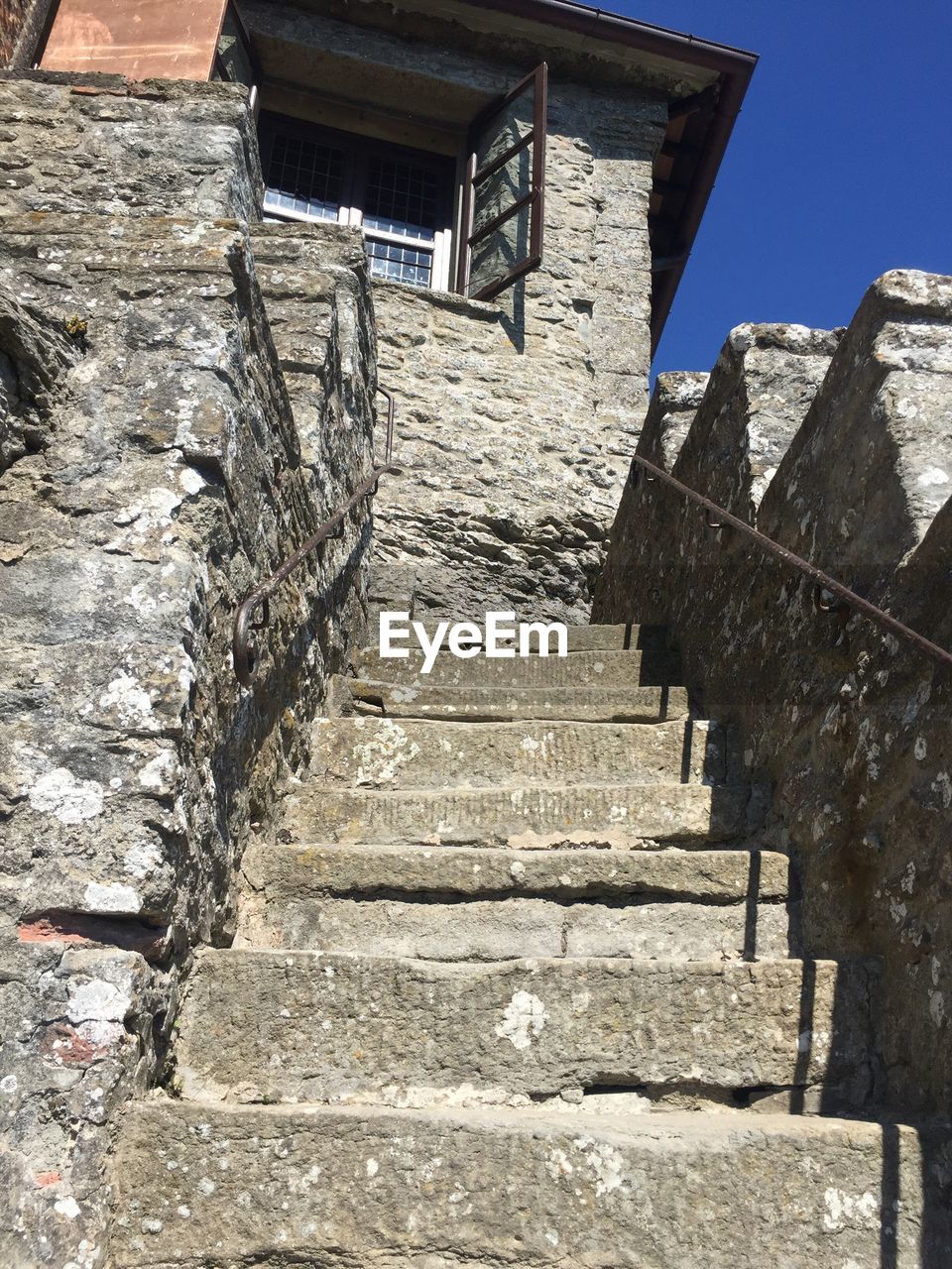 LOW ANGLE VIEW OF STAIRS ALONG BUILT STRUCTURES