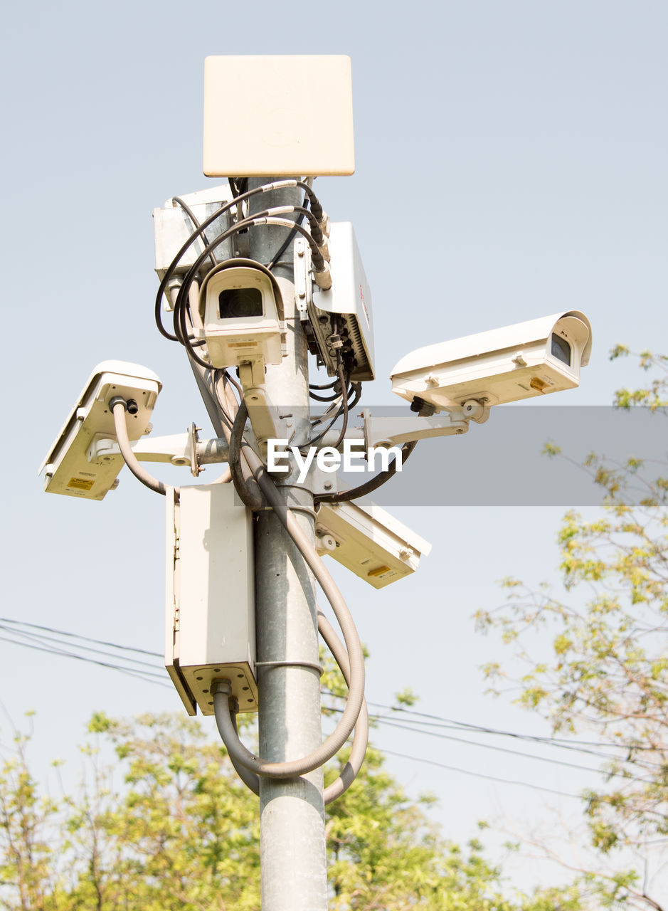 Low angle view of  surveillance camera against clear sky