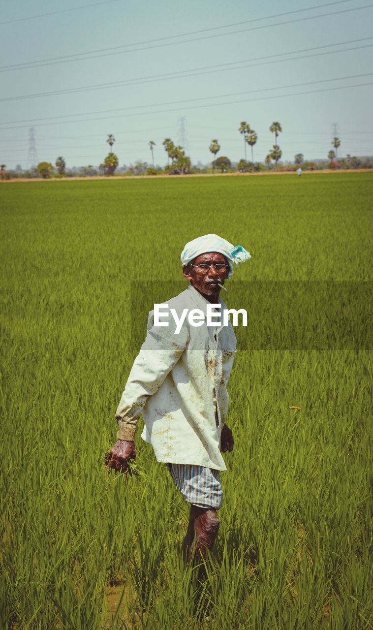 Man standing in field with a cigar