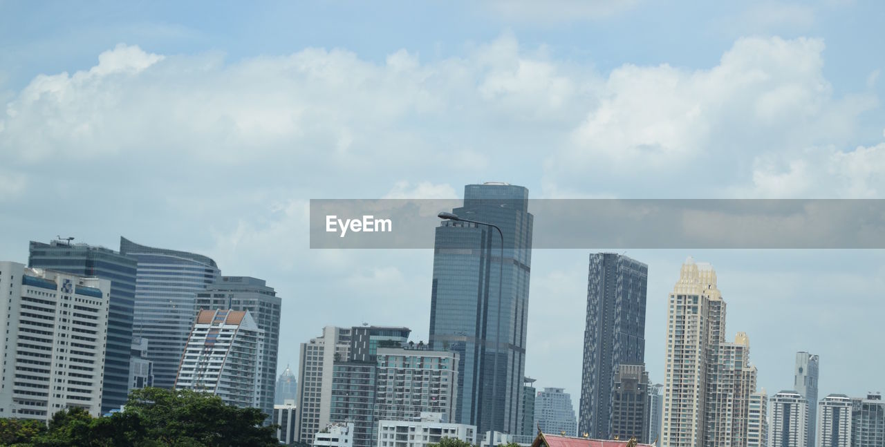 Low angle view of modern buildings against cloudy sky