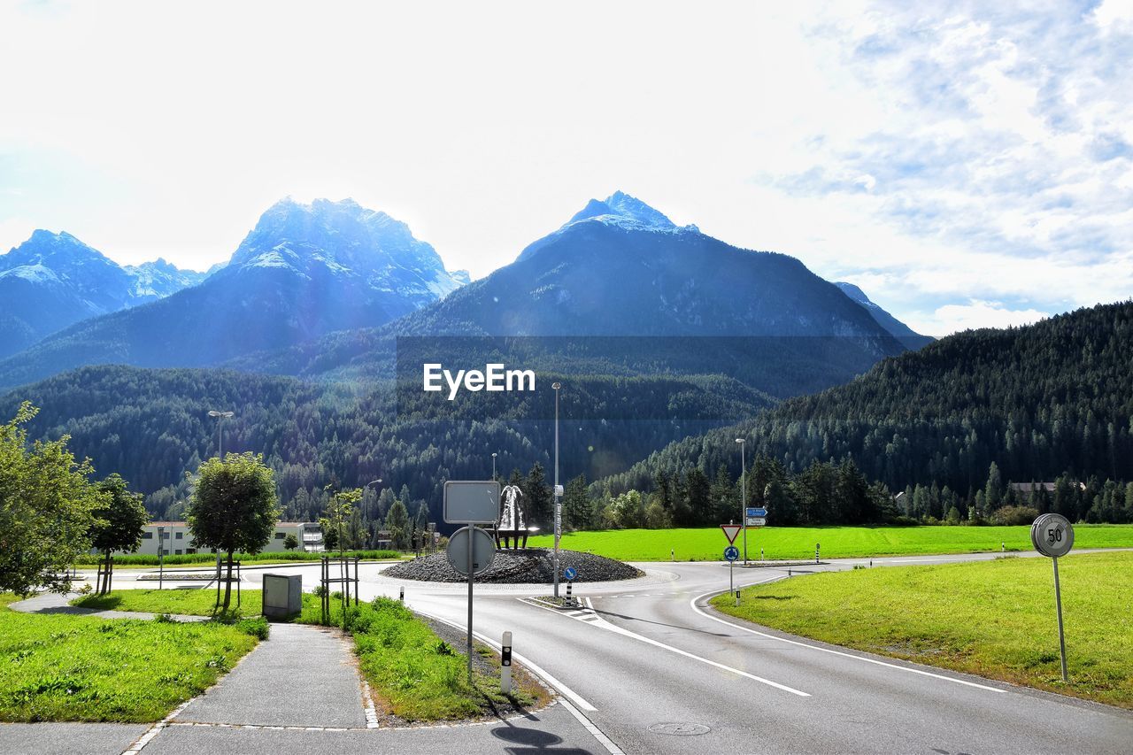 Road by mountains against sky