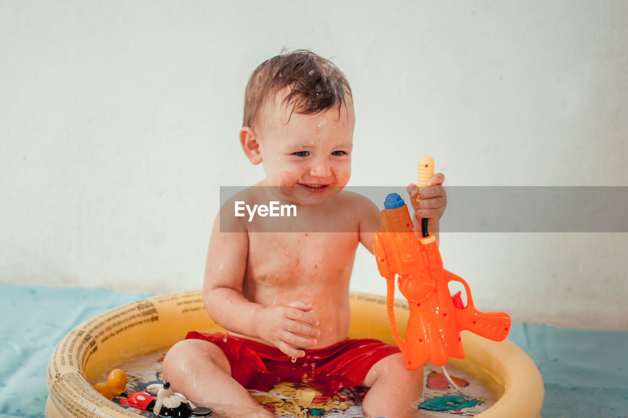 Shirtless baby boy having bath