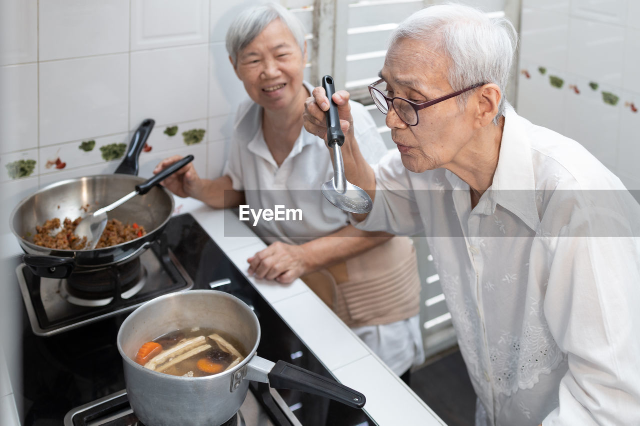 PEOPLE HAVING FOOD IN KITCHEN AT HOME