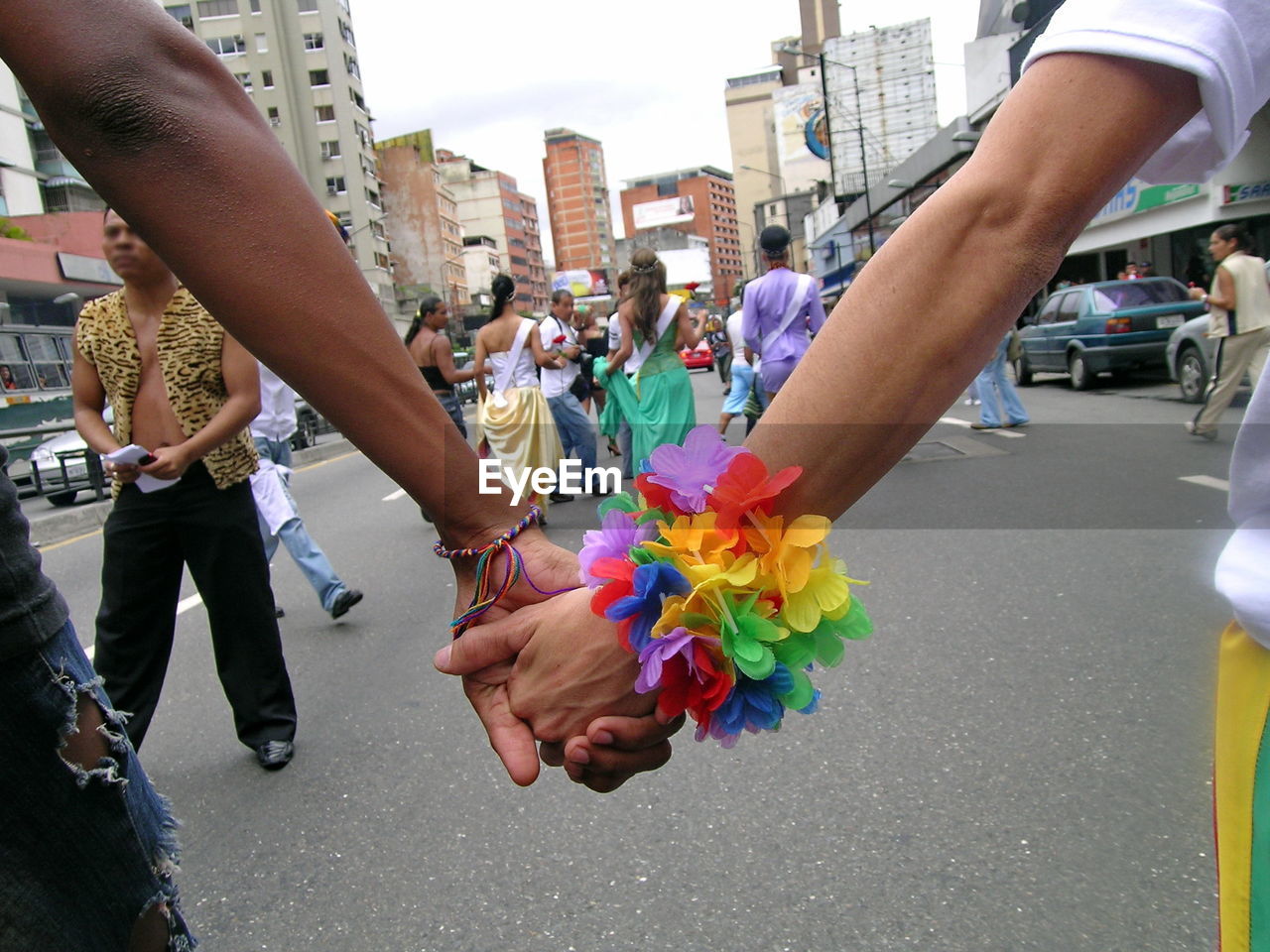 Cropped hands holding hands on street