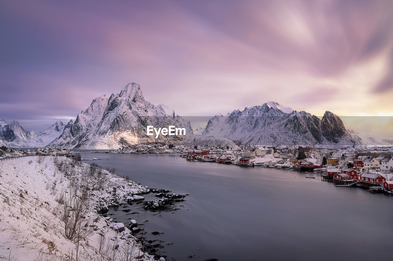 Scenic view of sea and snowcapped mountains against sky during sunset