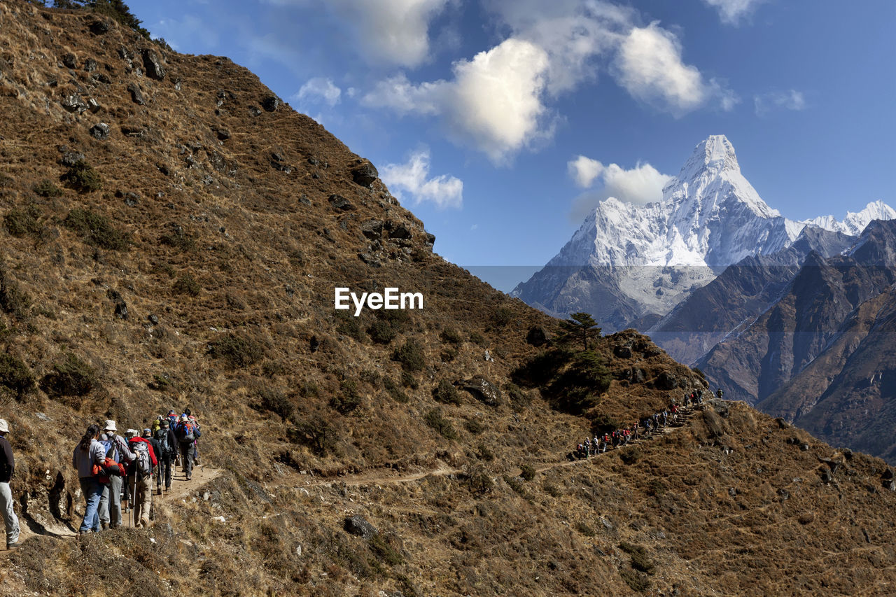 Trekking tourists overlooking mount ama dablam, khumbu region, nepal