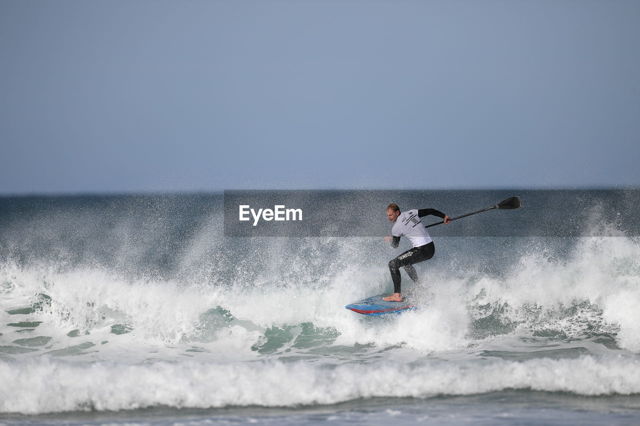 MAN SURFING ON SEA