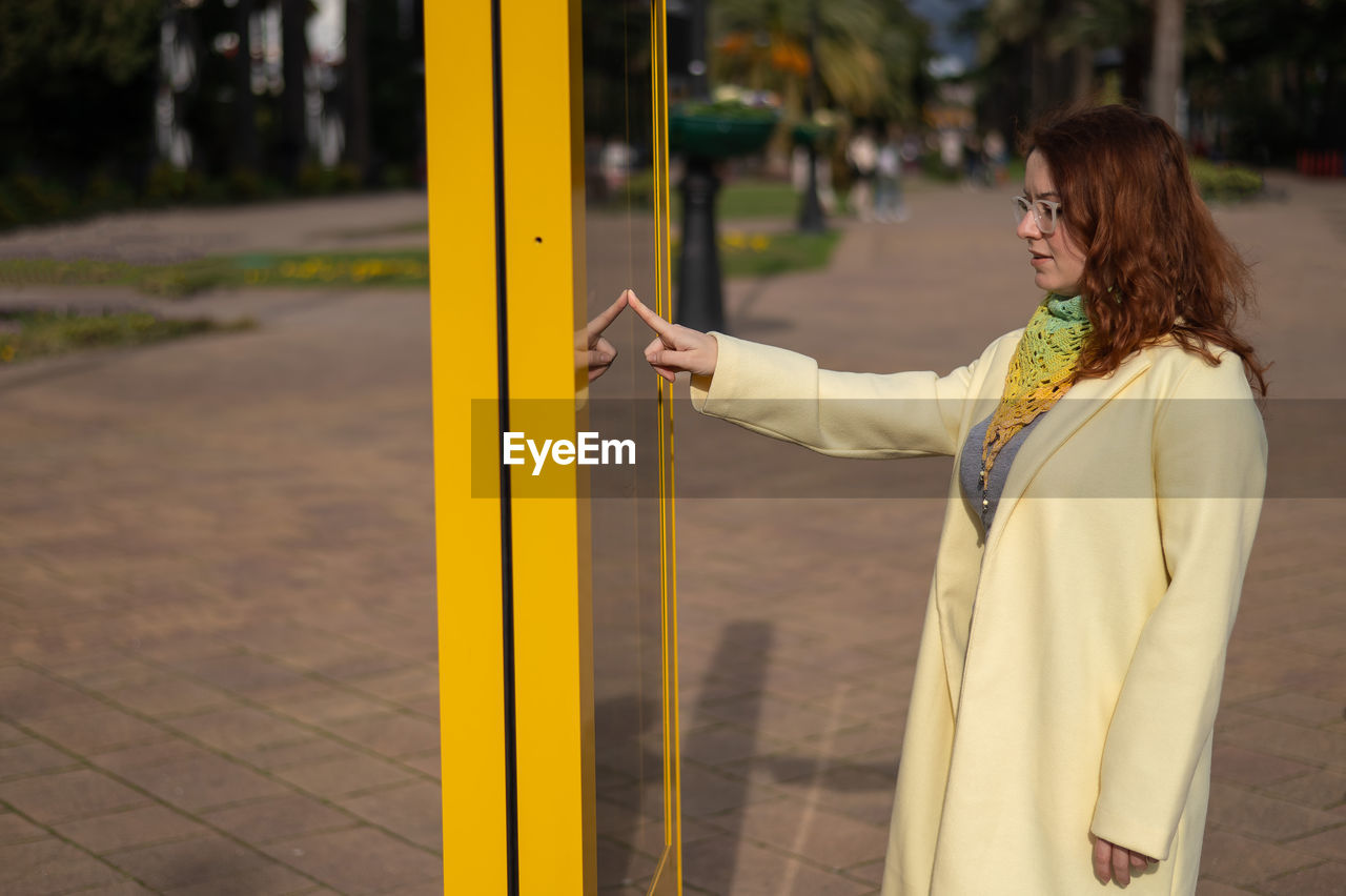 rear view of young woman standing in city