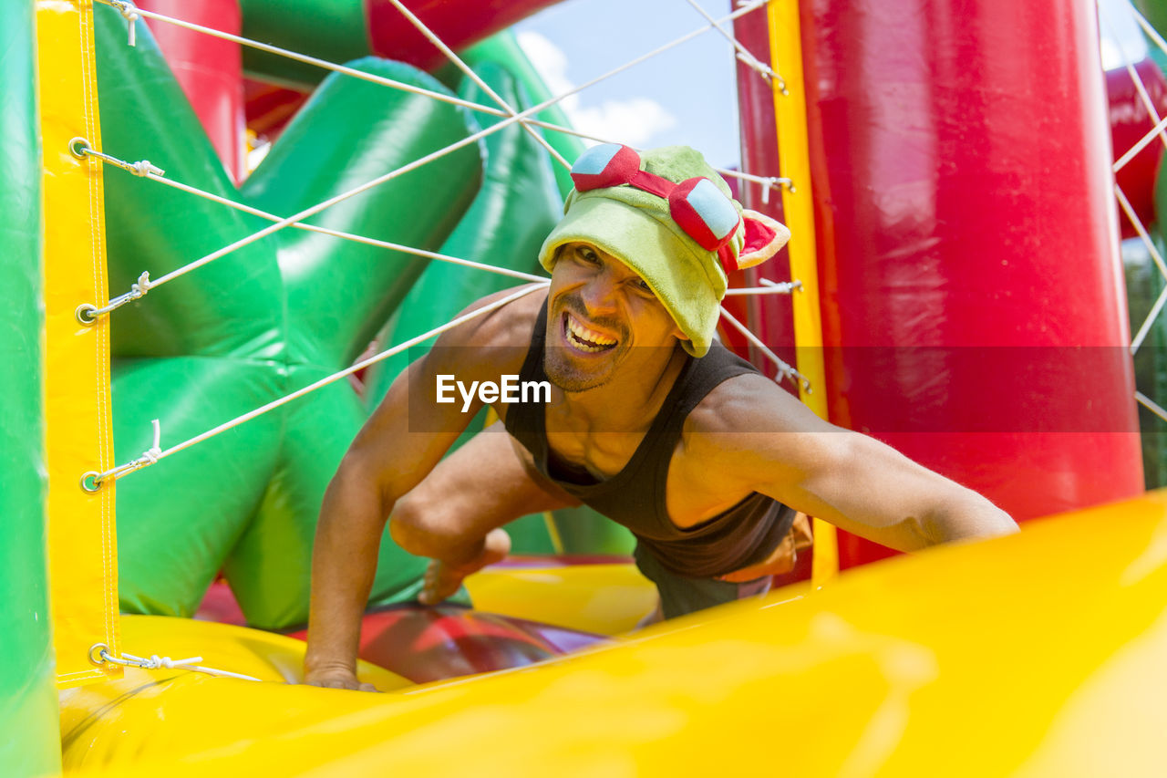Portrait of man playing on colorful bouncy castle