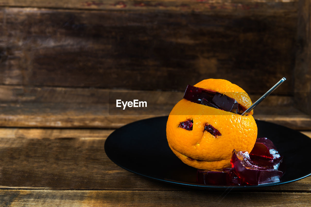 CLOSE-UP OF ORANGE SLICE ON TABLE