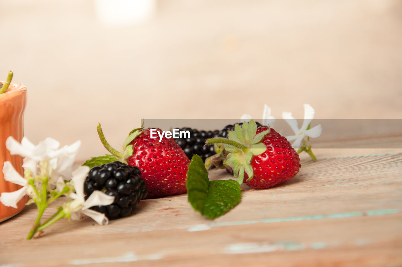 Close-up of strawberries and blackberries on wooden table