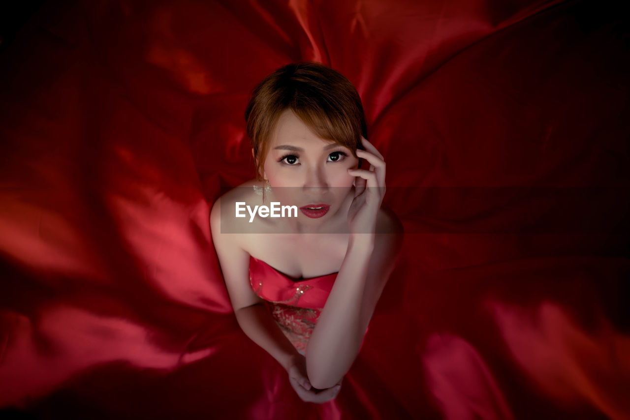 Portrait of beautiful young woman in red dress