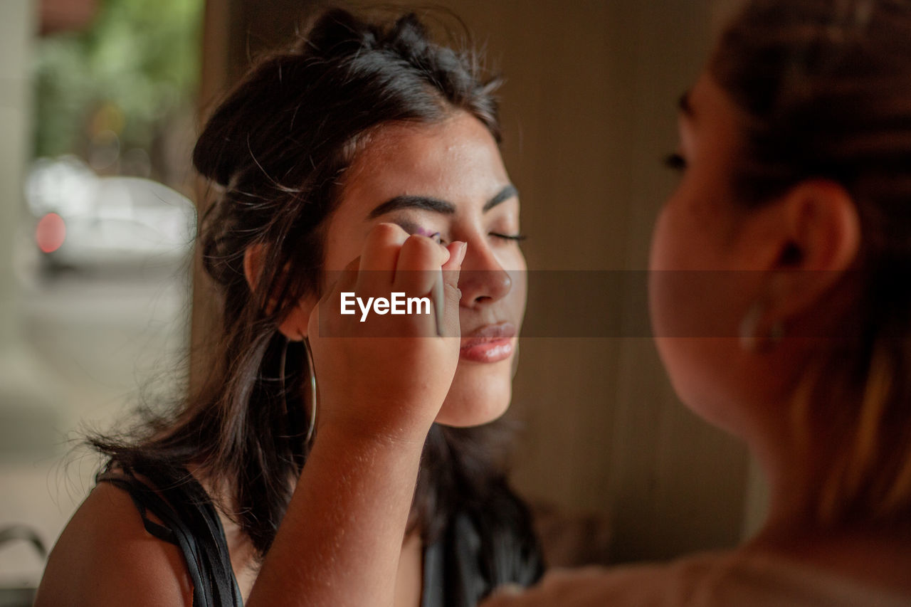 Make up artist working with a young woman