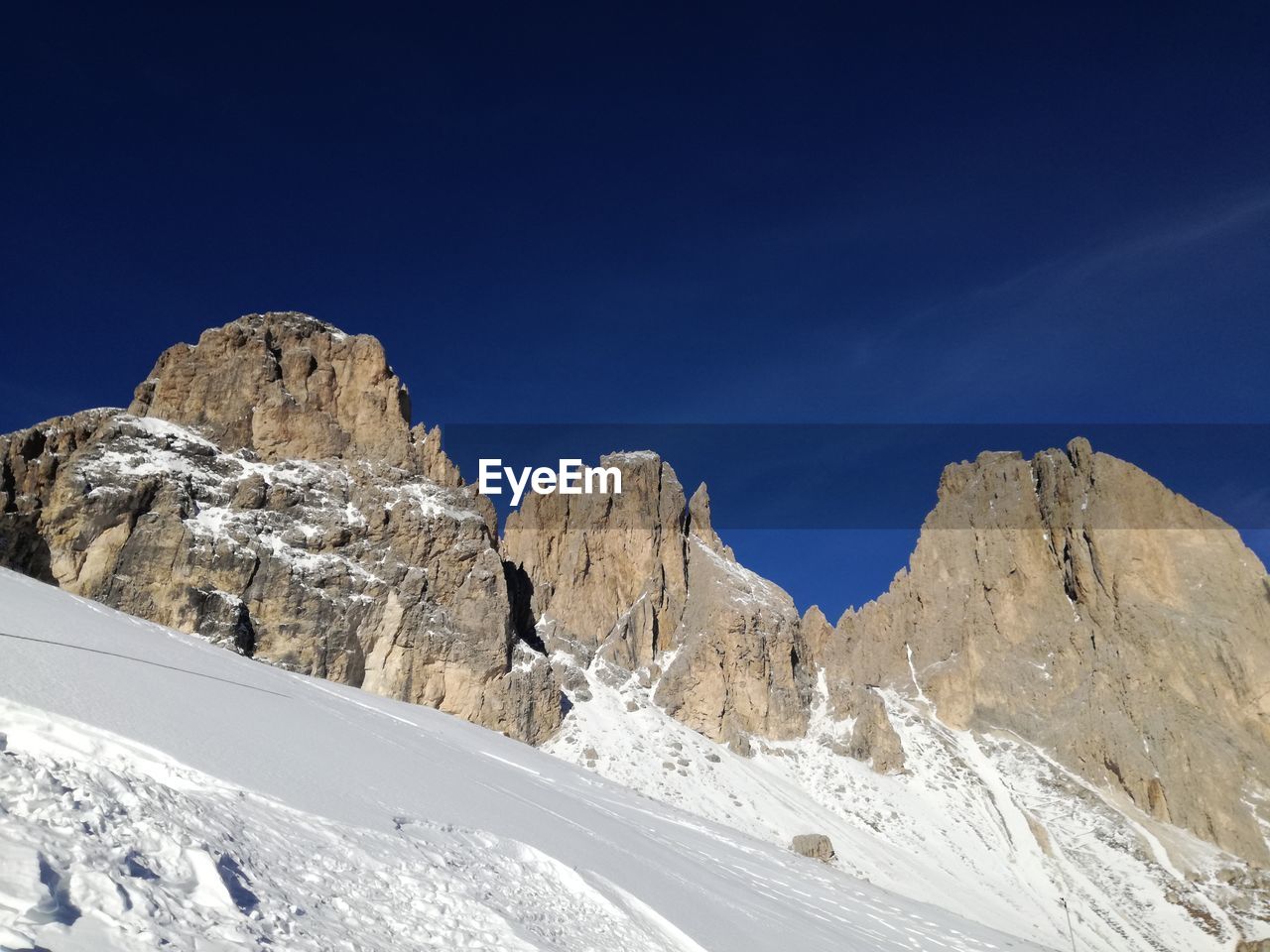 Low angle view of mountain against sky during winter