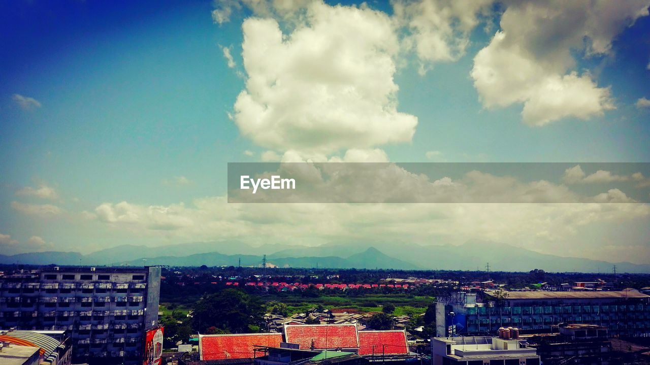 VIEW OF CITYSCAPE AGAINST CLOUDY SKY