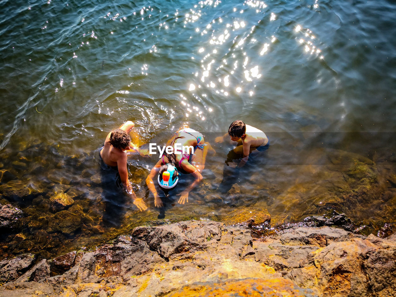 HIGH ANGLE VIEW OF PEOPLE ENJOYING IN WATER