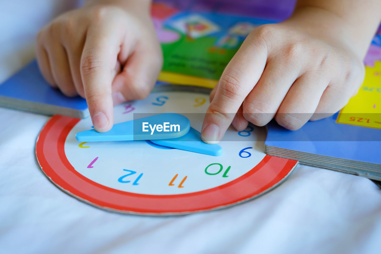 Kid play telling time game, young children to learn how to read an analog clock.