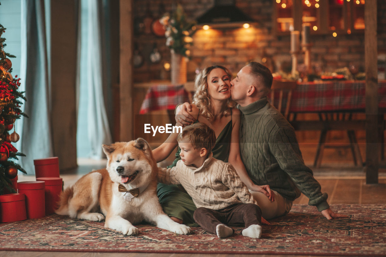 Candid authentic happy family during wintertime together enjoying holidays with dog at xmas