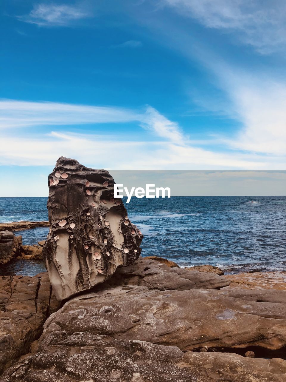 Rock formation on beach against sky