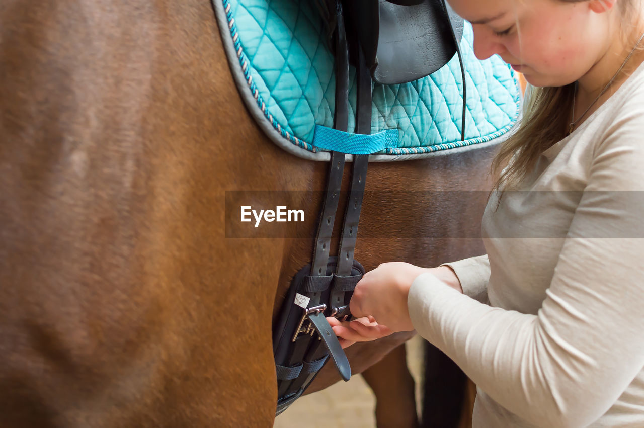 Woman locking horse saddle