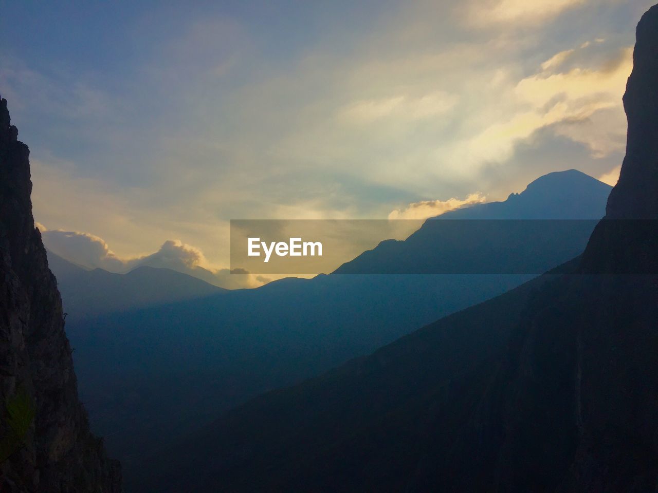 Scenic view of mountains against cloudy sky