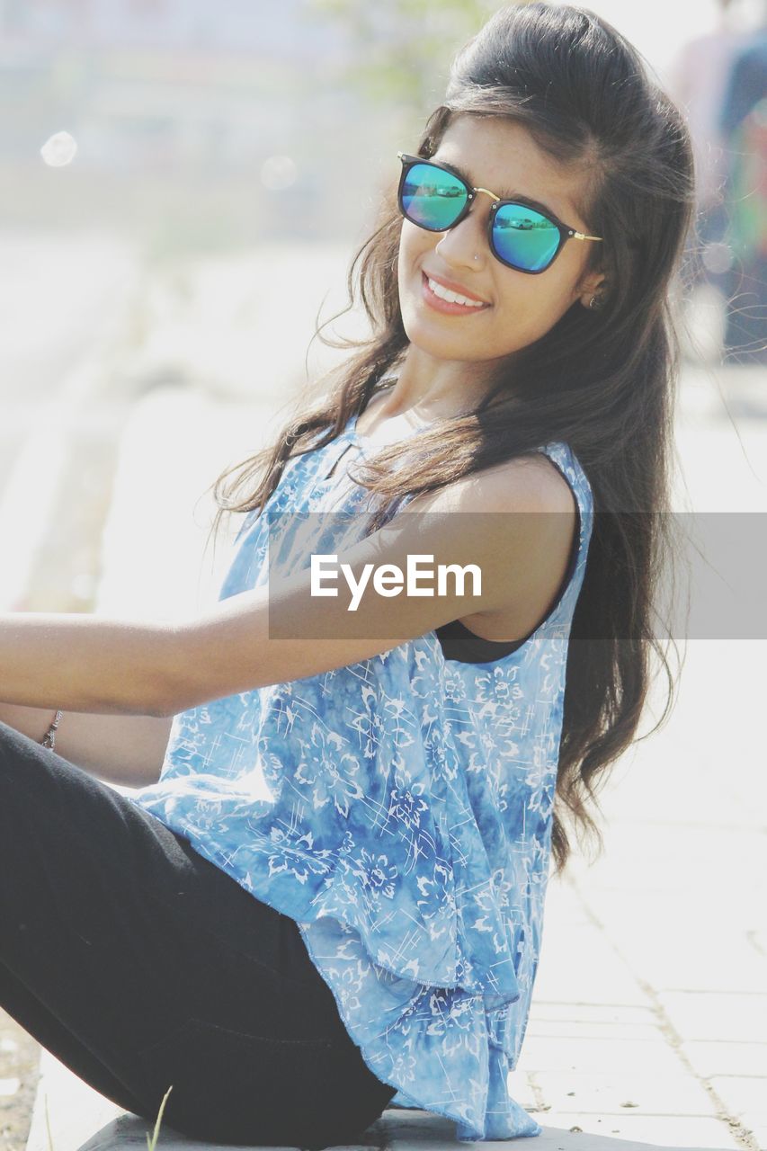 Portrait of smiling young woman wearing sunglasses