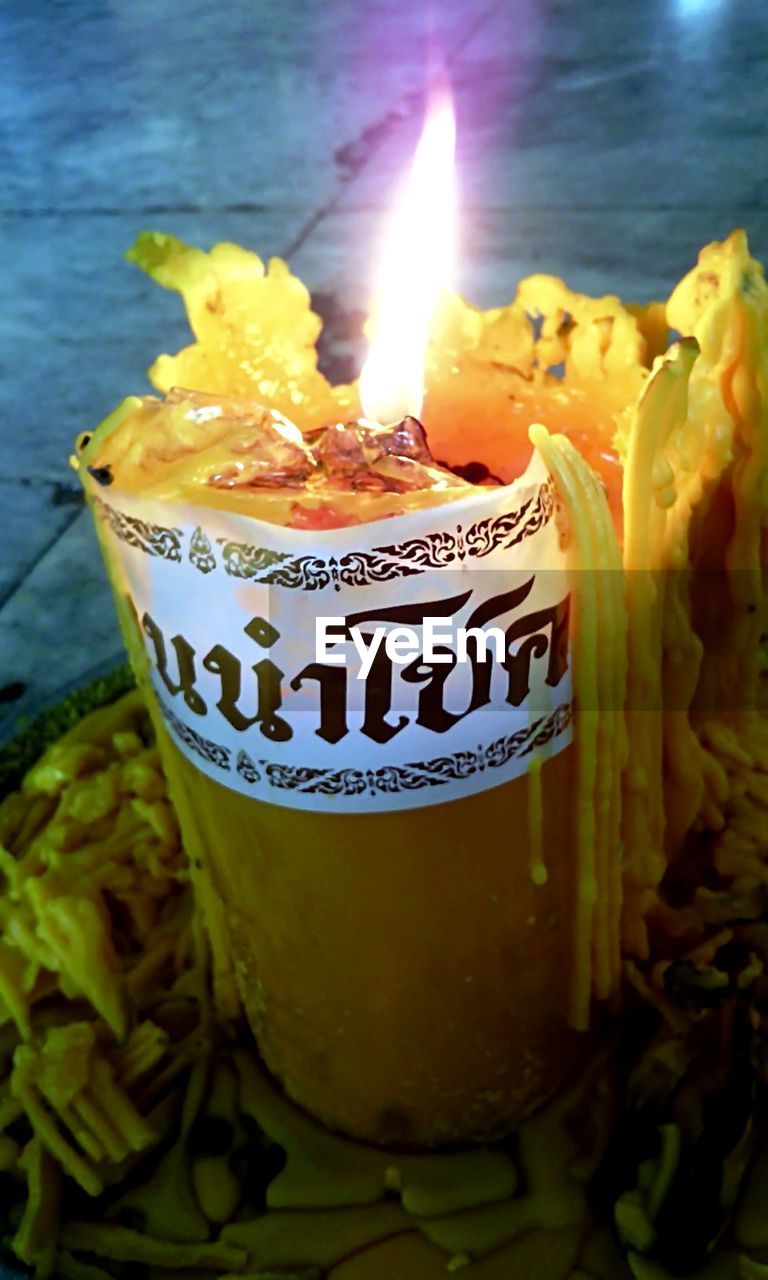 CLOSE-UP OF LIT CANDLES ON BIRTHDAY