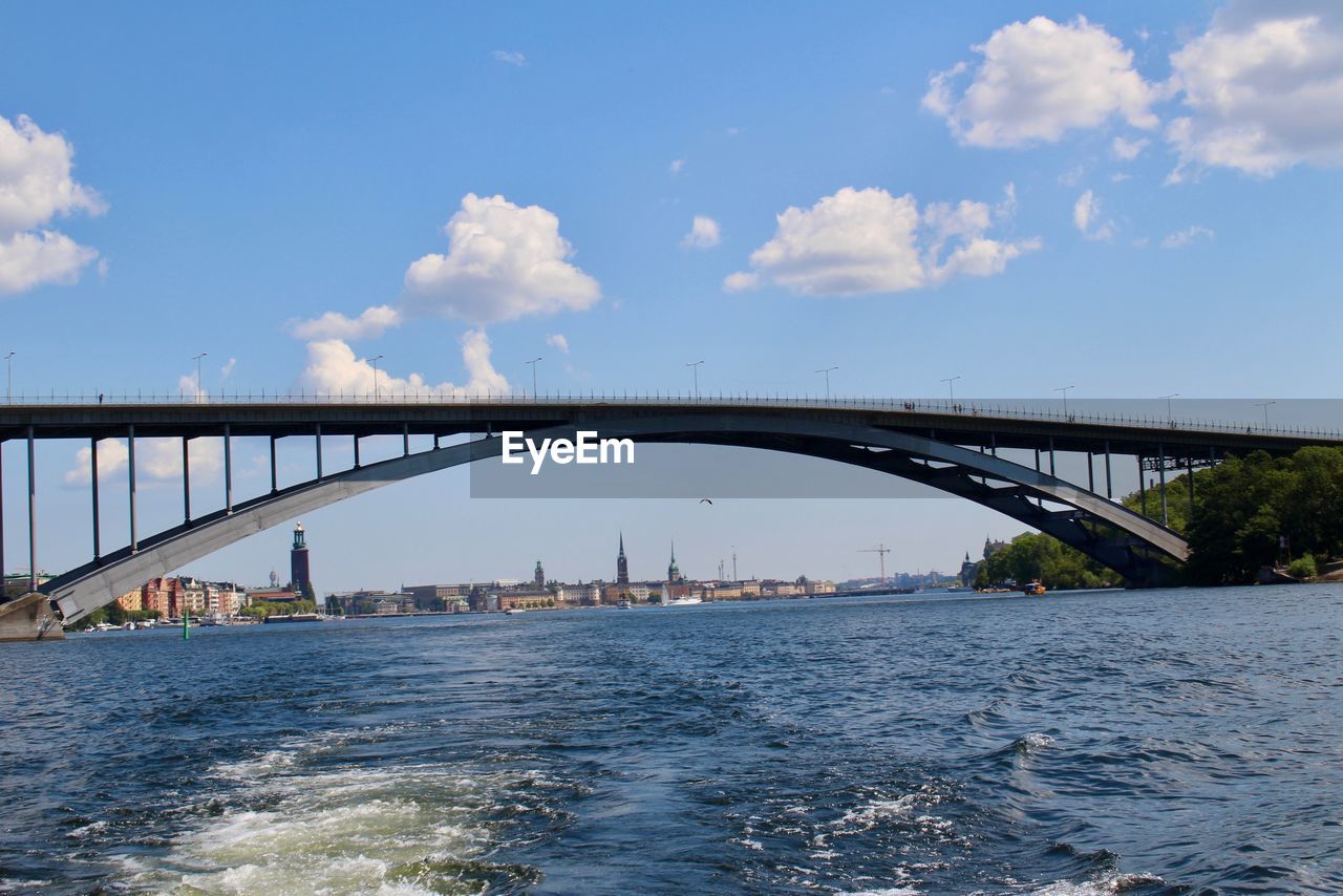 BRIDGE OVER RIVER IN CITY AGAINST SKY