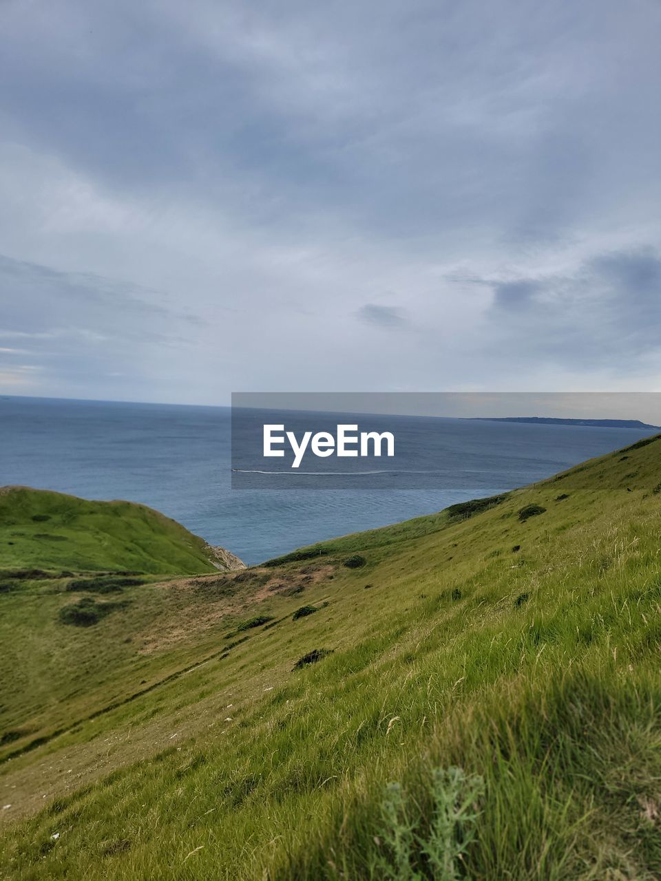 cloud, nature, sky, water, beauty in nature, scenics - nature, plant, no people, land, hill, terrain, day, environment, grass, green, coast, outdoors, sunlight, landscape, cliff, tranquility, tranquil scene, aerial photography, sea, motion, horizon, non-urban scene, panoramic, mountain range, reflection, beach