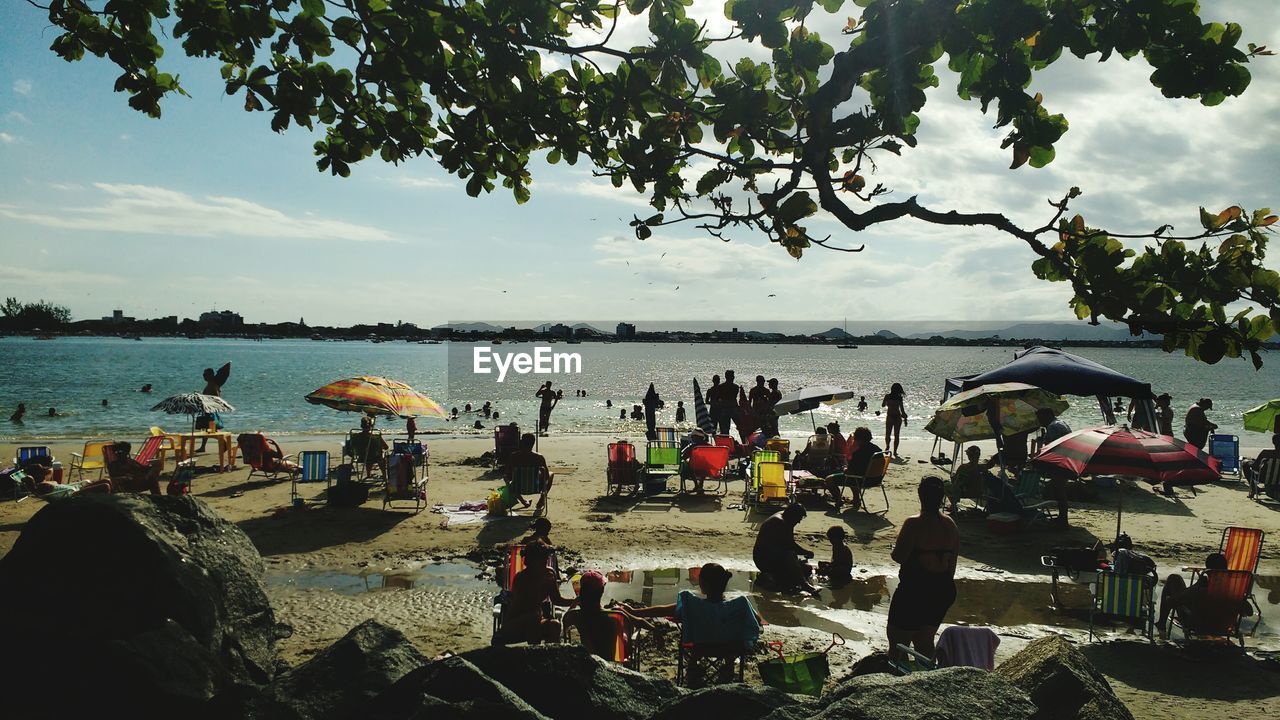 PEOPLE AT BEACH AGAINST SKY