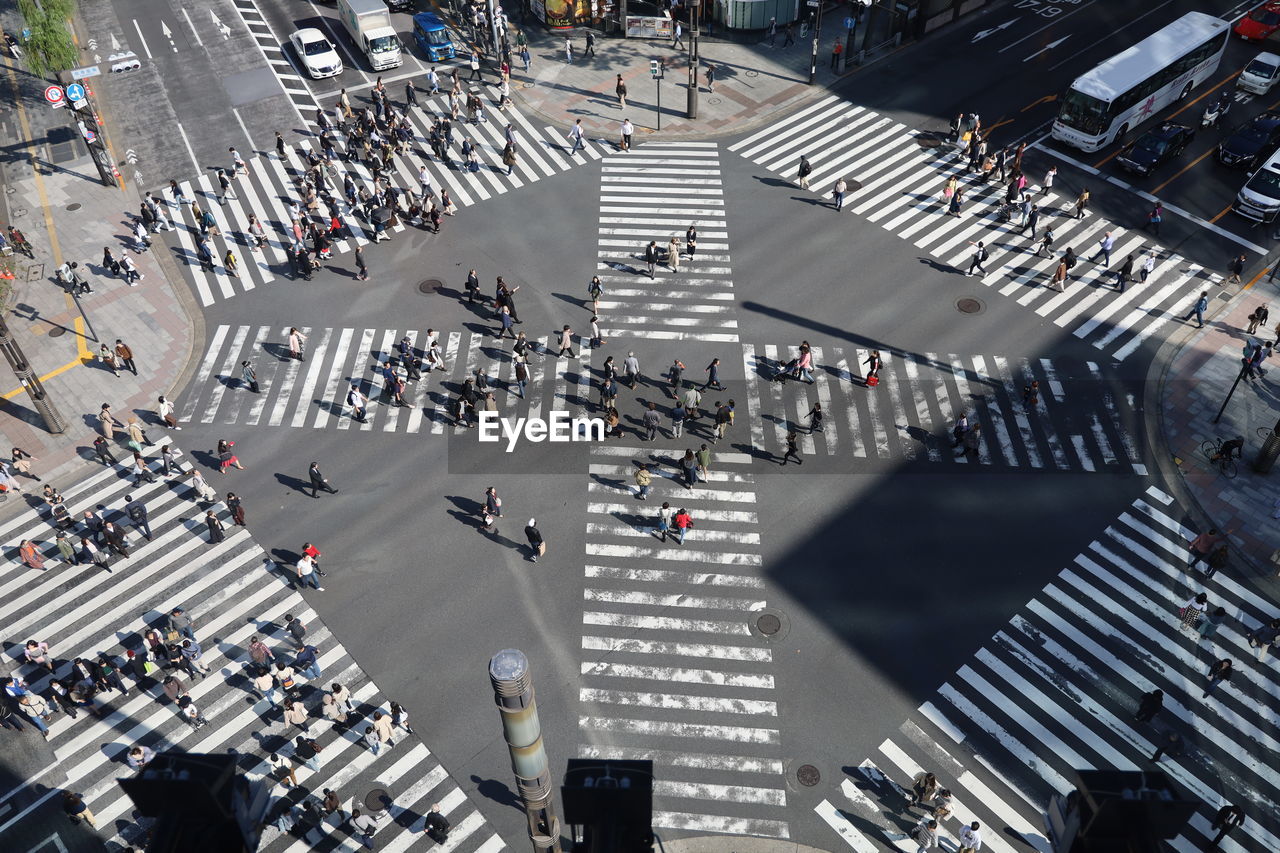 HIGH ANGLE VIEW OF PEOPLE CROSSING ON ROAD