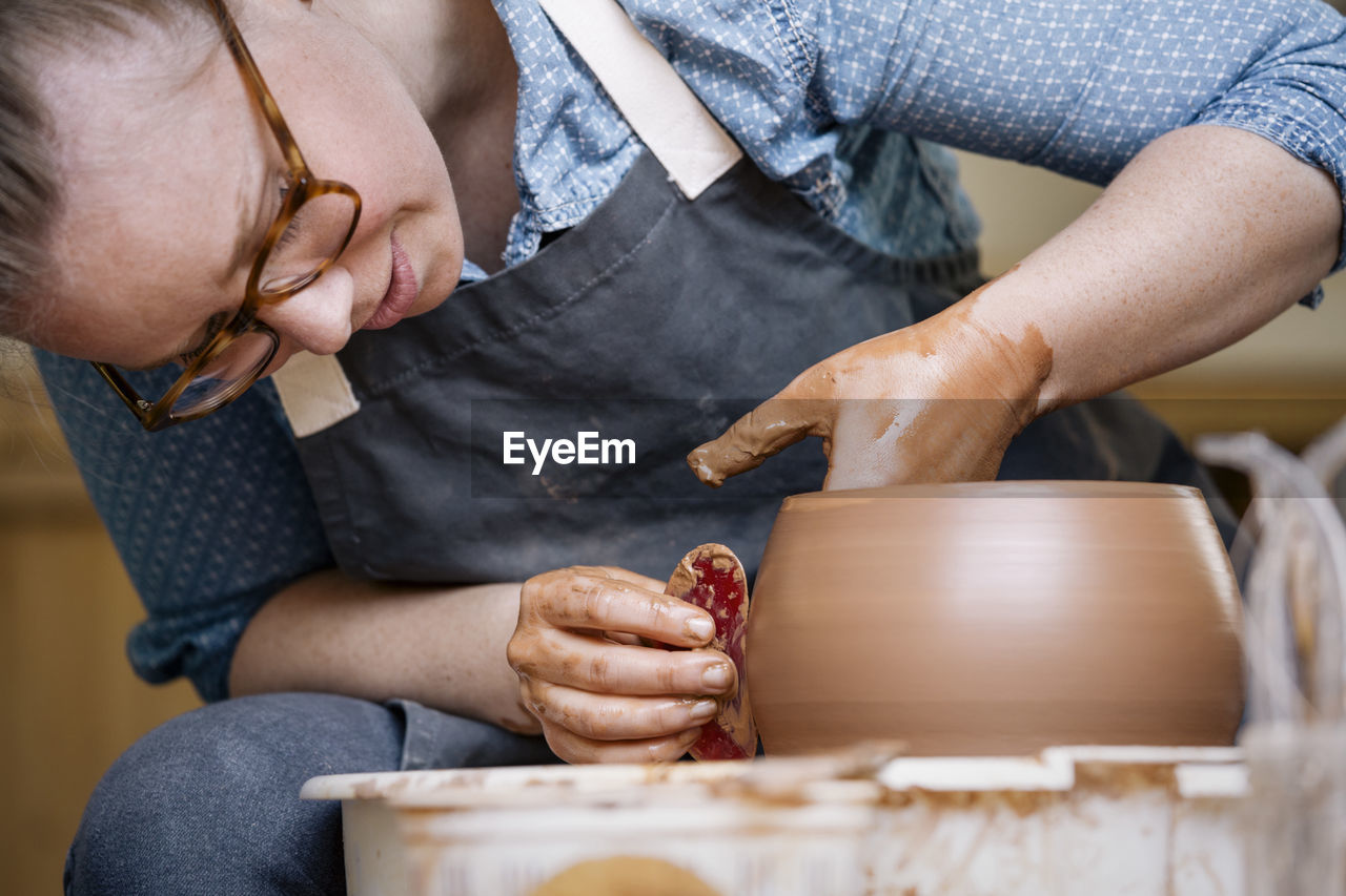 Close-up of woman molding shape on pottery wheel