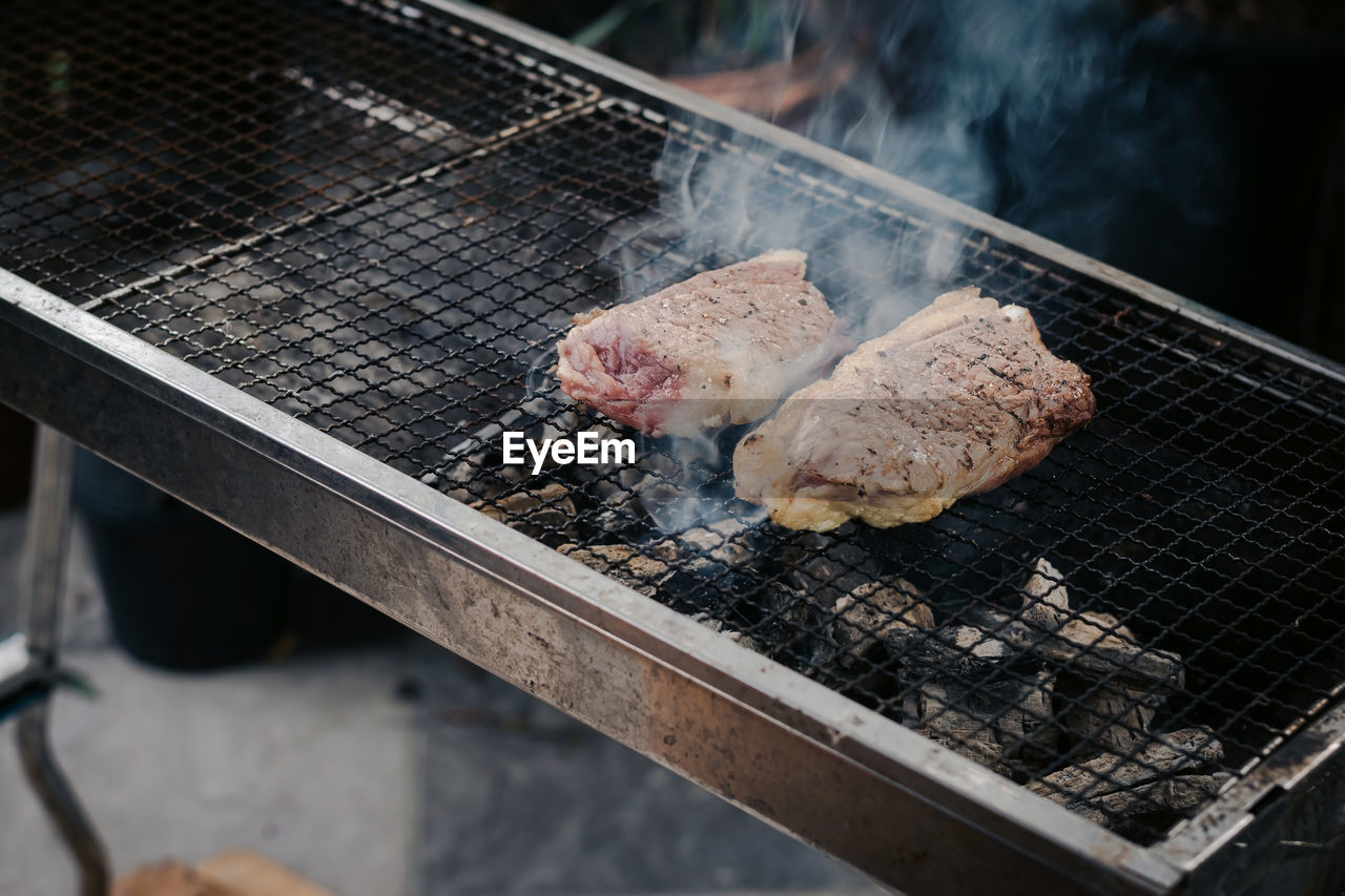 Closeup grill the beef on the charcoal grill to cook steaks.